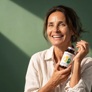 Femme souriante tenant le flacon de DuoWell D3+K2 de Naturadika
