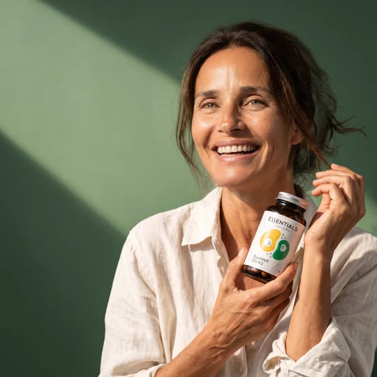 Femme souriante tenant le flacon de DuoWell D3+K2 de Naturadika